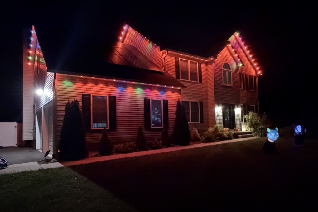 Columbus, New Jersey home with red and multicolor permanent outdoor lights along the rooflines and gables
