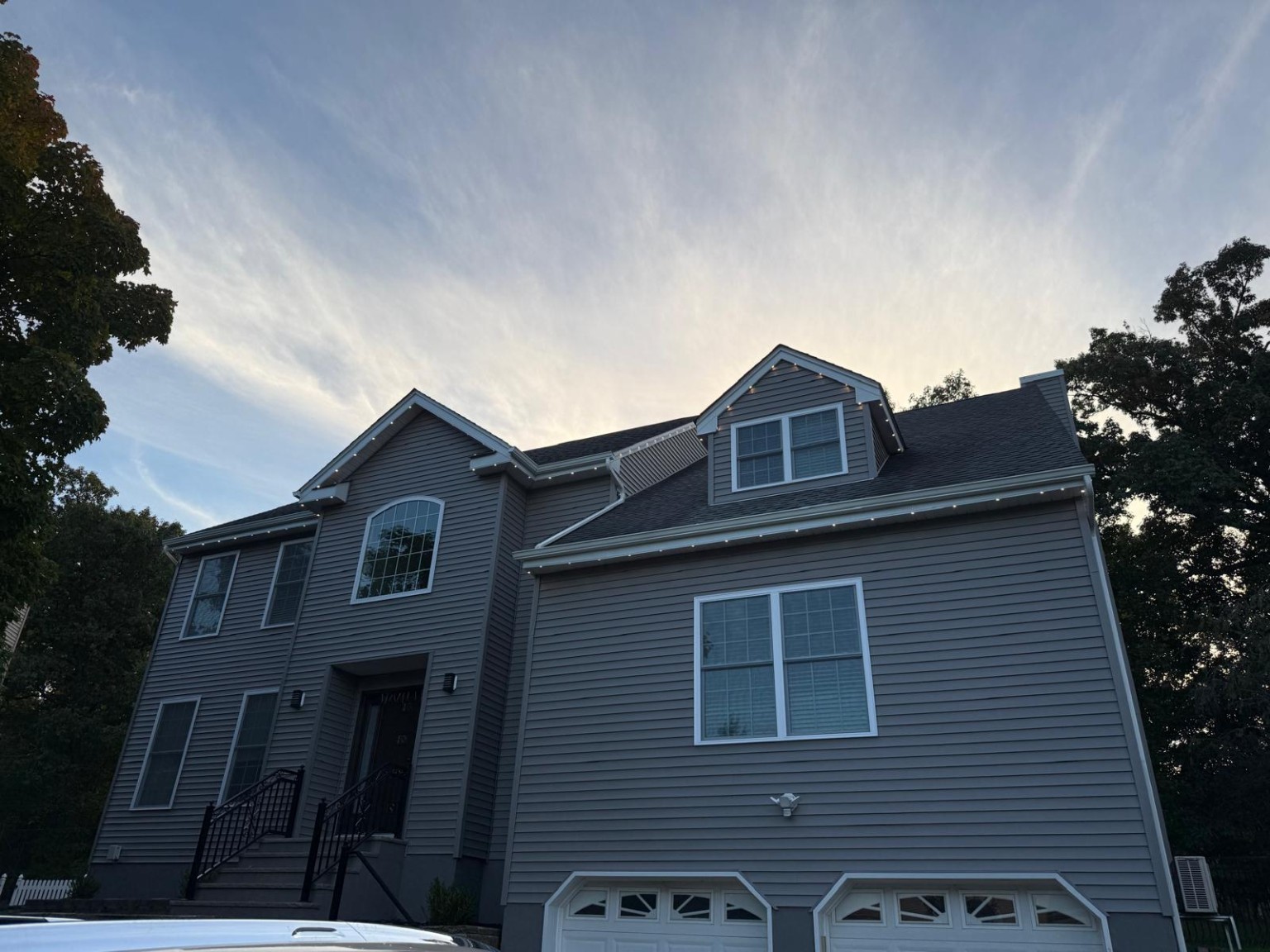 Completed Raritan home with warm white EverGlow lights and matching tracking along the front gable, dormer and roof edges